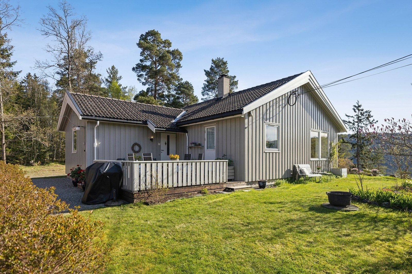 Terrasse ved inngangspartiet og en pent opparbeidet hage gir boligen et attraktivt og innbydende uttrykk fra første blikk. Galleribilde