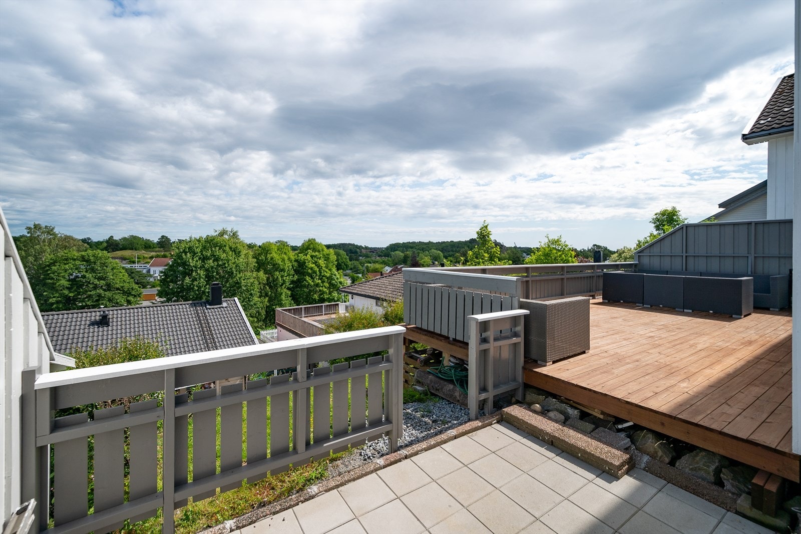 Uteplassene er fordelt på begge sider av boligen, med en stor treterrasse og en mindre, hellelagt sone. Galleribilde