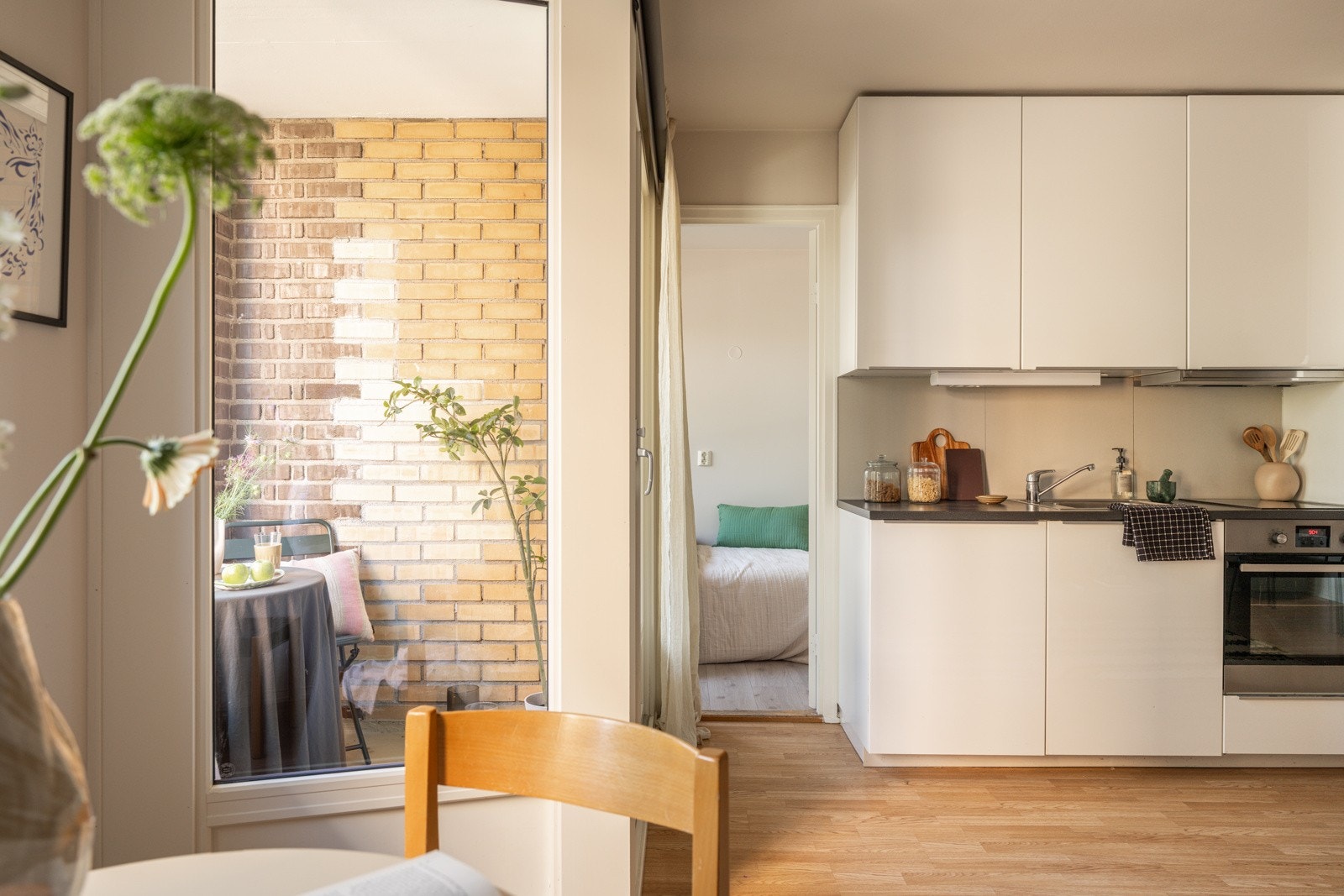 Lyst og moderne Ikea-kjøkken fra 2015 med hvite glatte fronter og laminert benkeplate med nedfelt oppvaskkum. Både fint og praktisk med fliser i benkeryggen og belysning under overskap. Galleribilde
