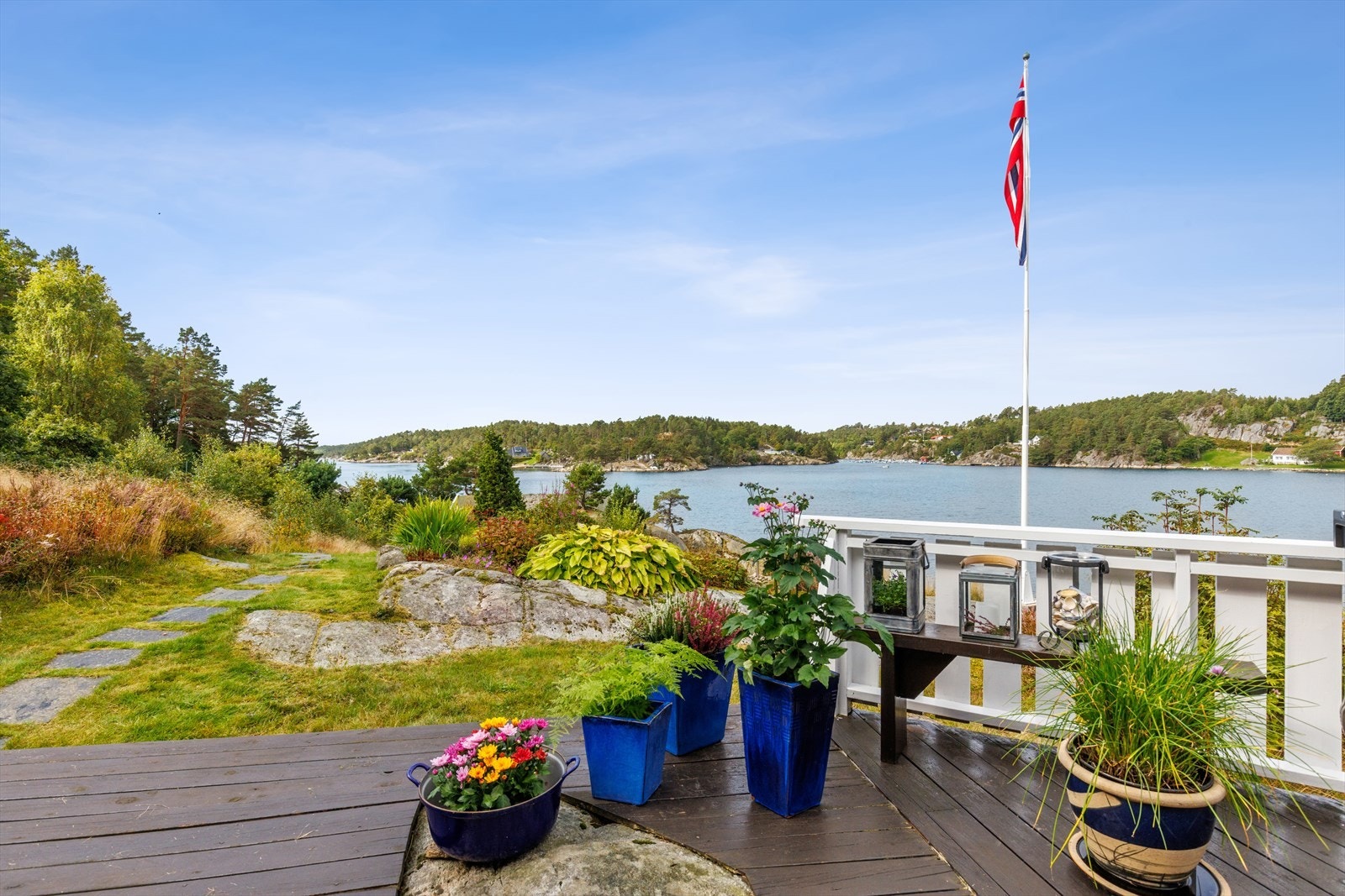 Tomten er opparbeidet med plen, svaberg og beplantning som glir naturlig inn i terrenget. Galleribilde