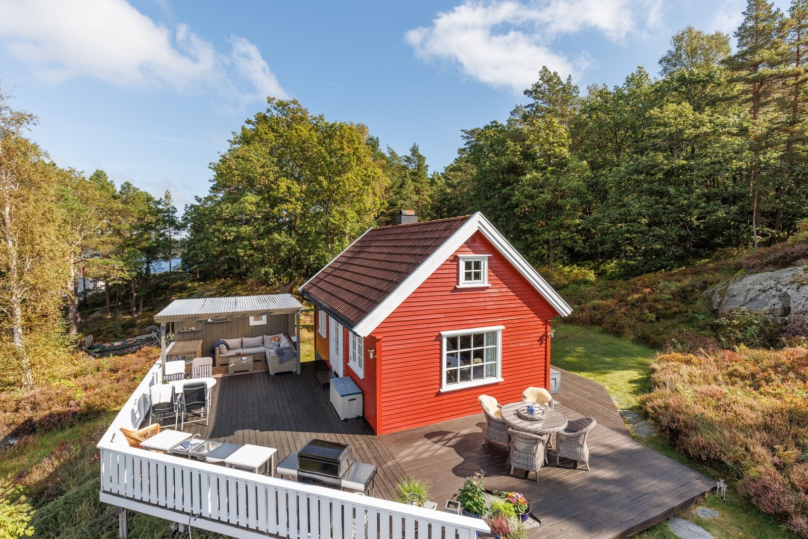 Eiendommen består av en sjarmerende hytte og et separat anneks, omkranset av en treterrasse på hele 80 m². Galleribilde