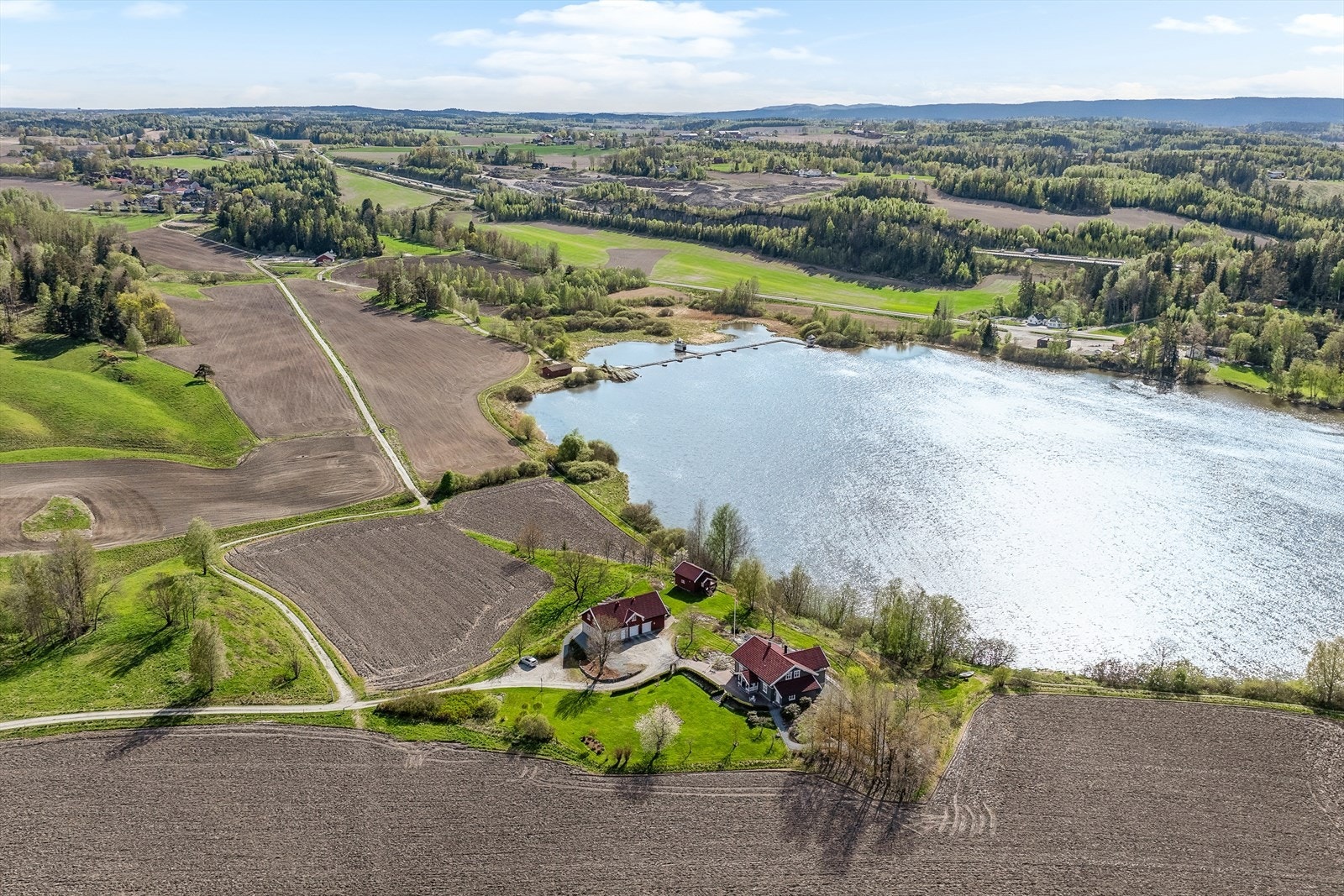 Eiendommen ligger idyllisk til på en liten åkerholme, vakkert omkranset av dyrket mark, med Årungen mot vest. Samtidig har du Ås sentrum kun ca. 3 km unna . En sjelden kombinasjon av landlig ro og nærhet til alle fasiliteter. Galleribilde