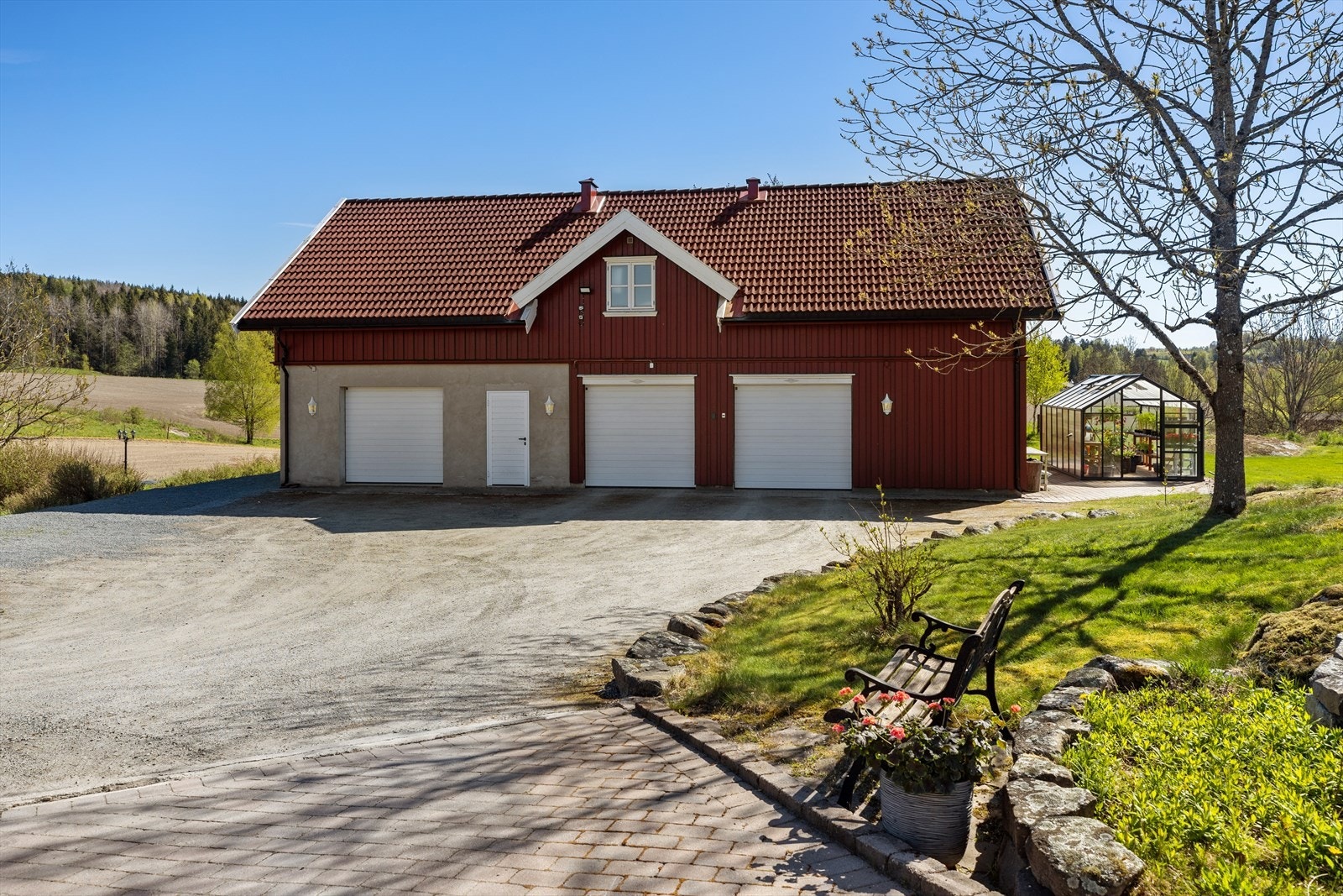 Garasjen fra 2013 er en solid og romslig bygning med tre leddporter med automatisk åpning, hobbyrom, teknisk rom og to boder i 1. etasje. Over garasjen ligger en godkjent utleieleilighet med fire soverom, to bad/vaskerom, stue/kjøkken og gang. Galleribilde