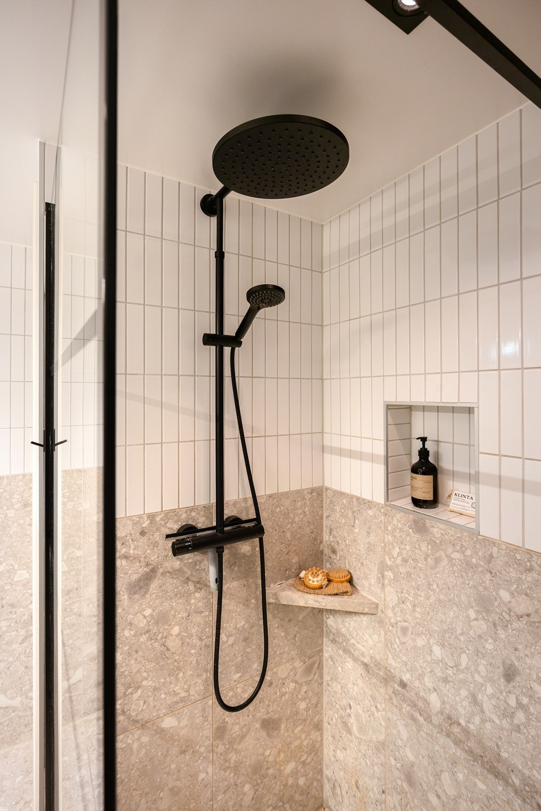 Badet er utstyrt med baderomsinnredning, speilskap med overlys, dusjnisje med glassvegg og vegghengt toalett. Galleribilde