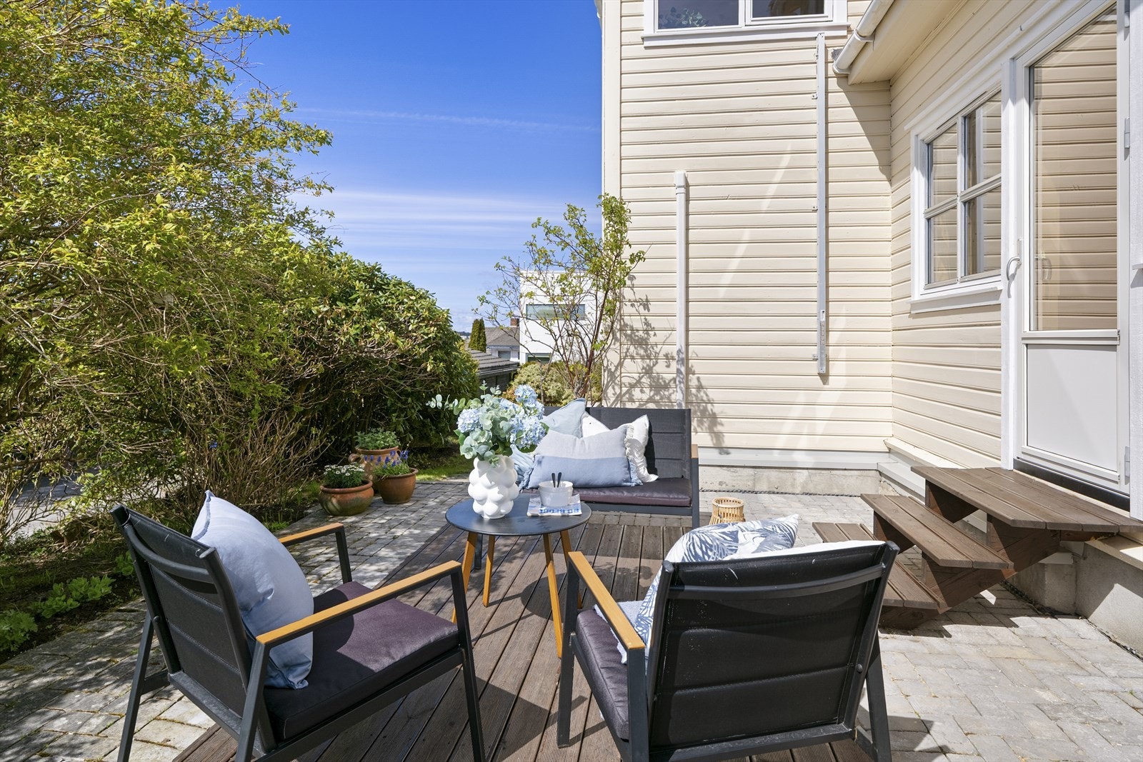 Flott opparbeidet uteområde fra stuen belagt med belegningsstein og terrasse hvor man har plass til sittegrupper og grill. Galleribilde