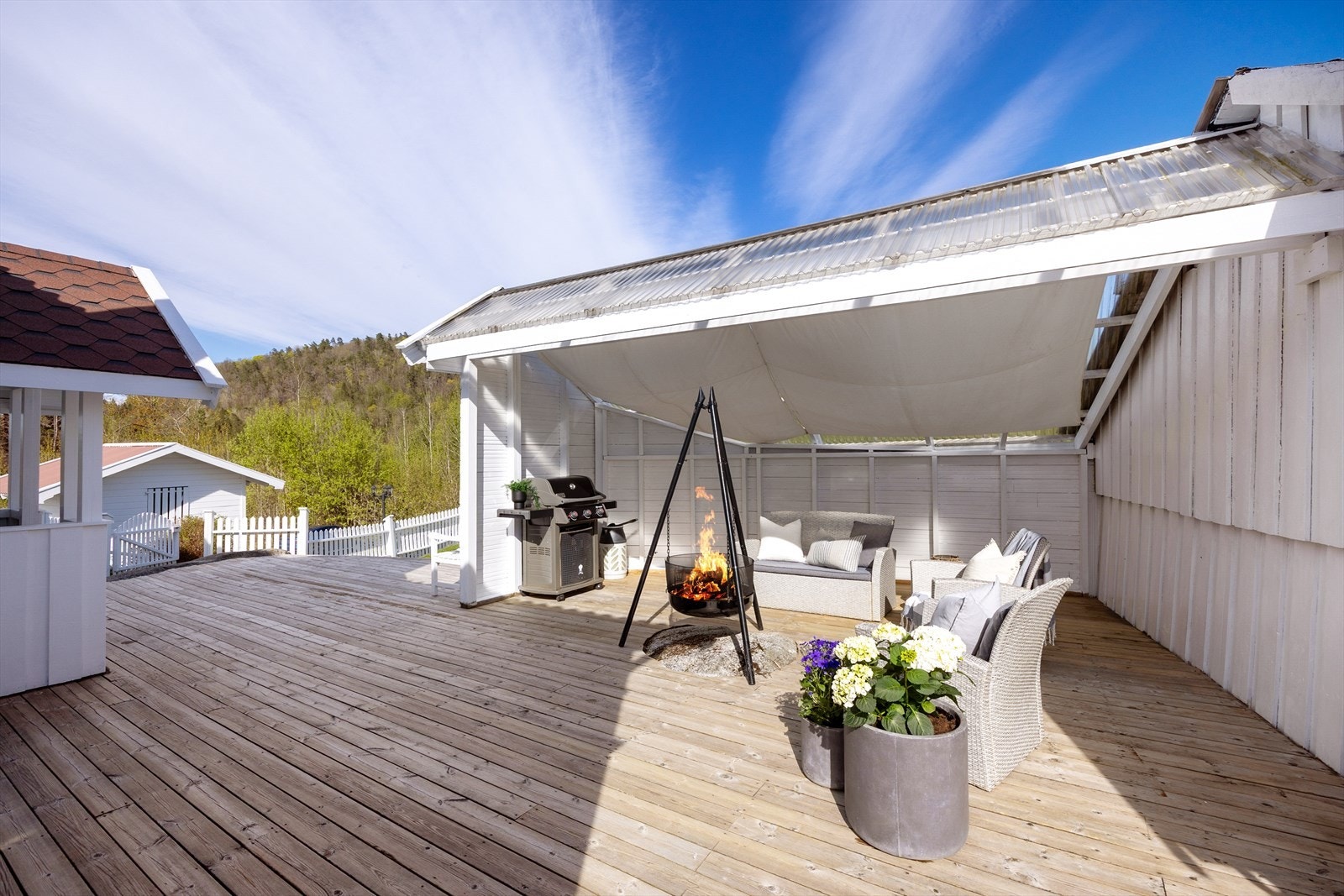 En sosial sone på terrassen med plass til sittegruppe og bålpanne. Galleribilde