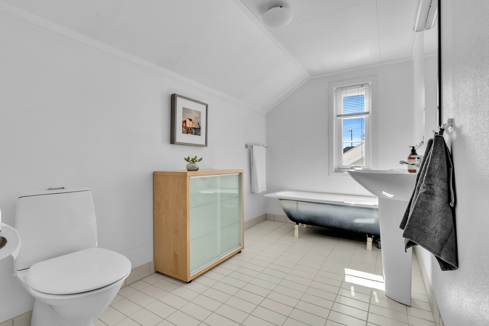 Lyst bad med god plass, badekar og praktisk innredning, varme i gulv Galleribilde