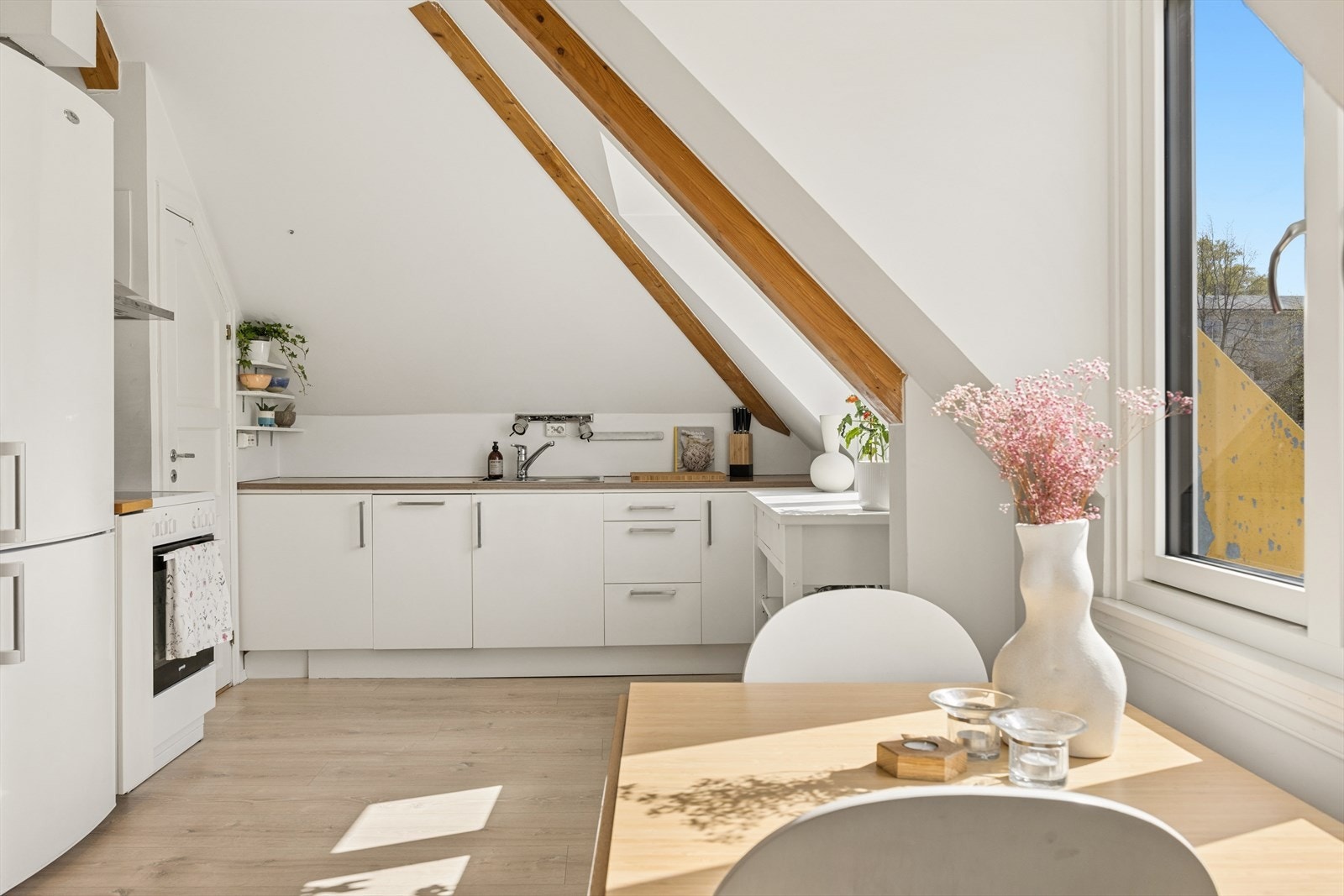 En arealeffektiv loftsleilighet med synlige takbjelker, nye 3-lags vinduer og dimbare spotter i himlingen. Galleribilde
