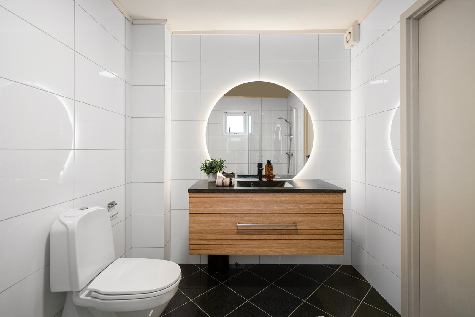 Det store runde speilet med integrert belysning løfter rommet og gir badet et moderne preg. Galleribilde