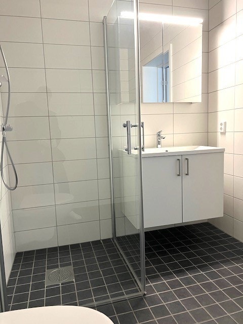 Bad med dusjhjørne og opplegg for vaskemaskin. Galleribilde