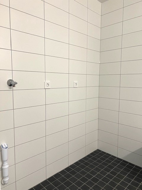 Bad med dusjhjørne og opplegg for vaskemaskin. Galleribilde