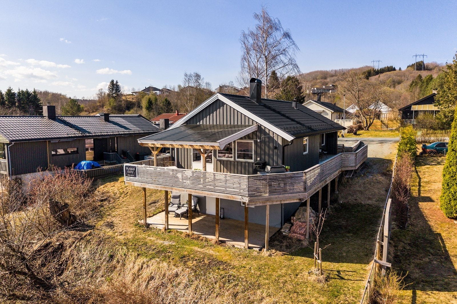 Boligen inkluderer en veranda med utgang fra stuen. I tillegg er verandaen knyttet sammen med terrasse ved inngangspartiet. Inngang til utleie i sokkel. Galleribilde
