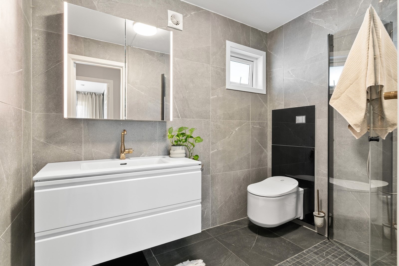 Badet ble oppgradert i 2019/2020 og har flislagte overflater med mekanisk avtrekk for ventilasjon. Lekre fargevalg. Toalettdusj fra kvalitetsleverandøren Grohe. Galleribilde