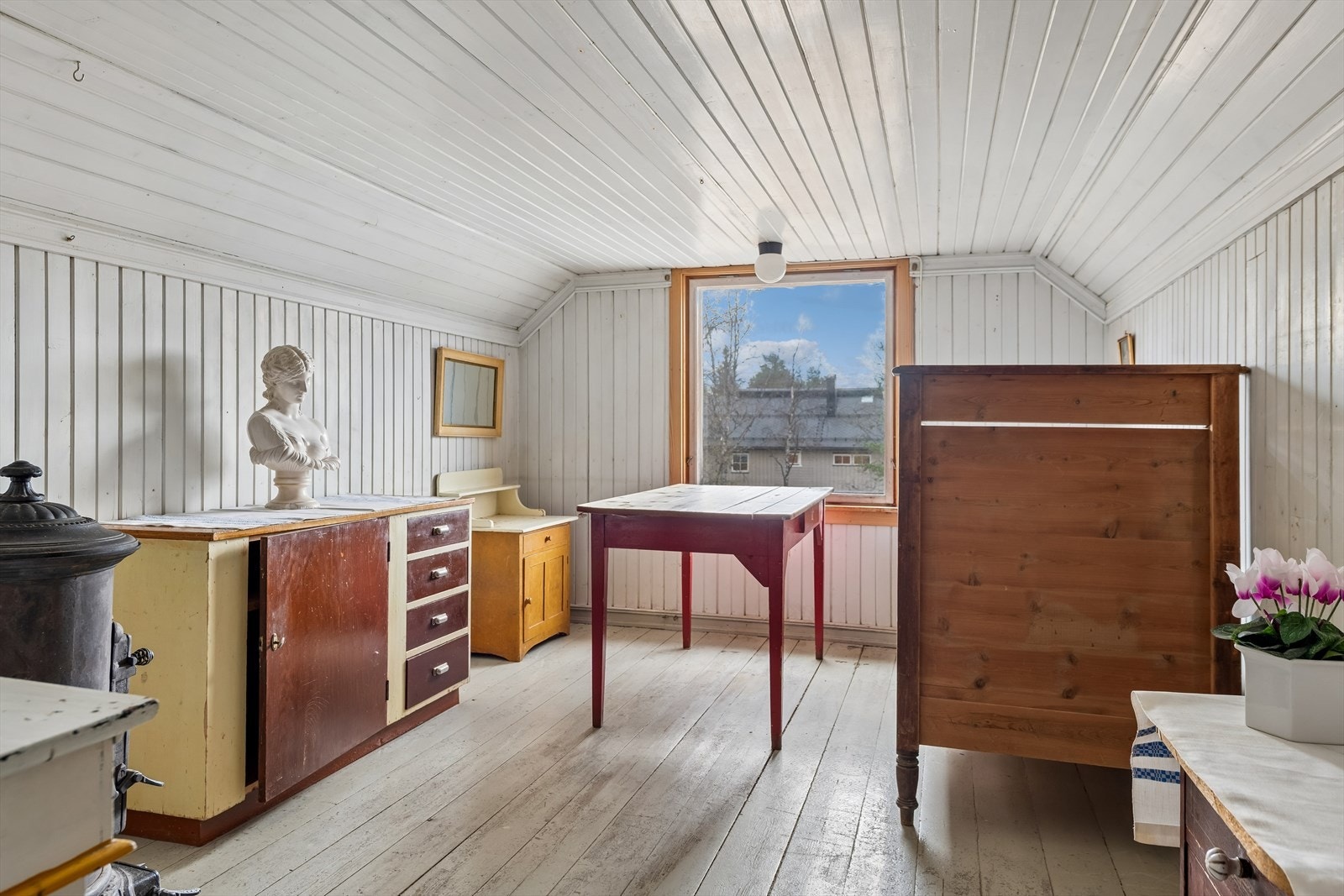 Loftet har innredede rom med malte tregulv og panelte overflater. Galleribilde