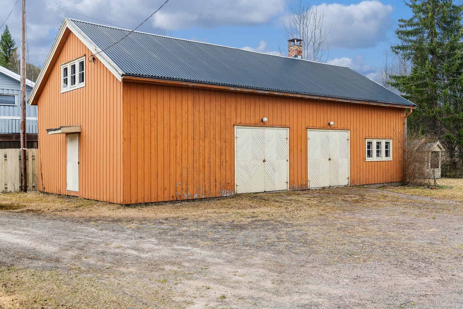 Et separat garasje- og uthusbygg med to garasjeporter gir rikelig med plass til kjøretøy og lagring. Bygget har innlagt strøm. Galleribilde