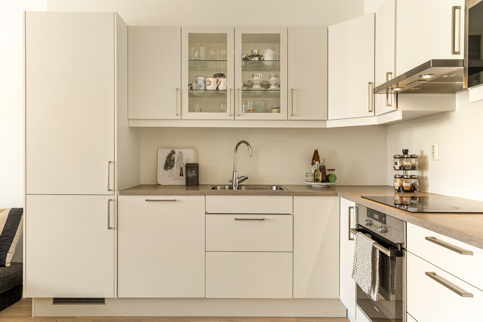 Kjøkkenet har delikat innredning med slette, hvite fronter og lys benkeplate av laminat. Galleribilde