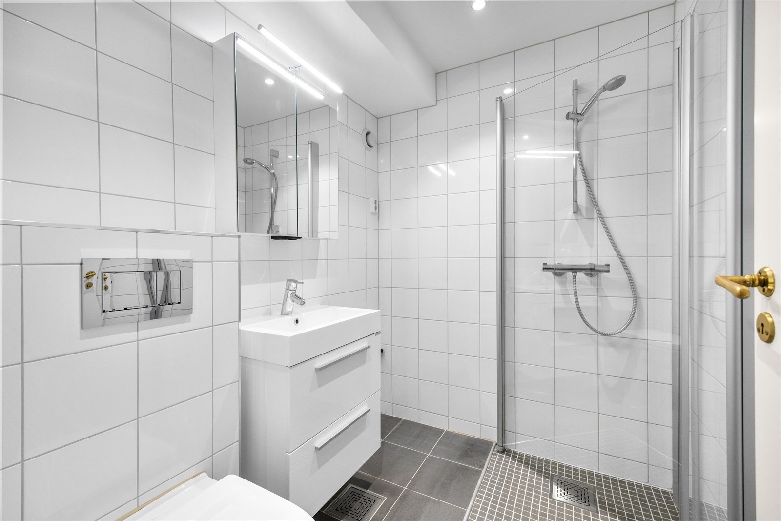 Badet har rene og tidløse detaljer som flislagte overflater, elektrisk gulvvarme og downlights i taket. Galleribilde
