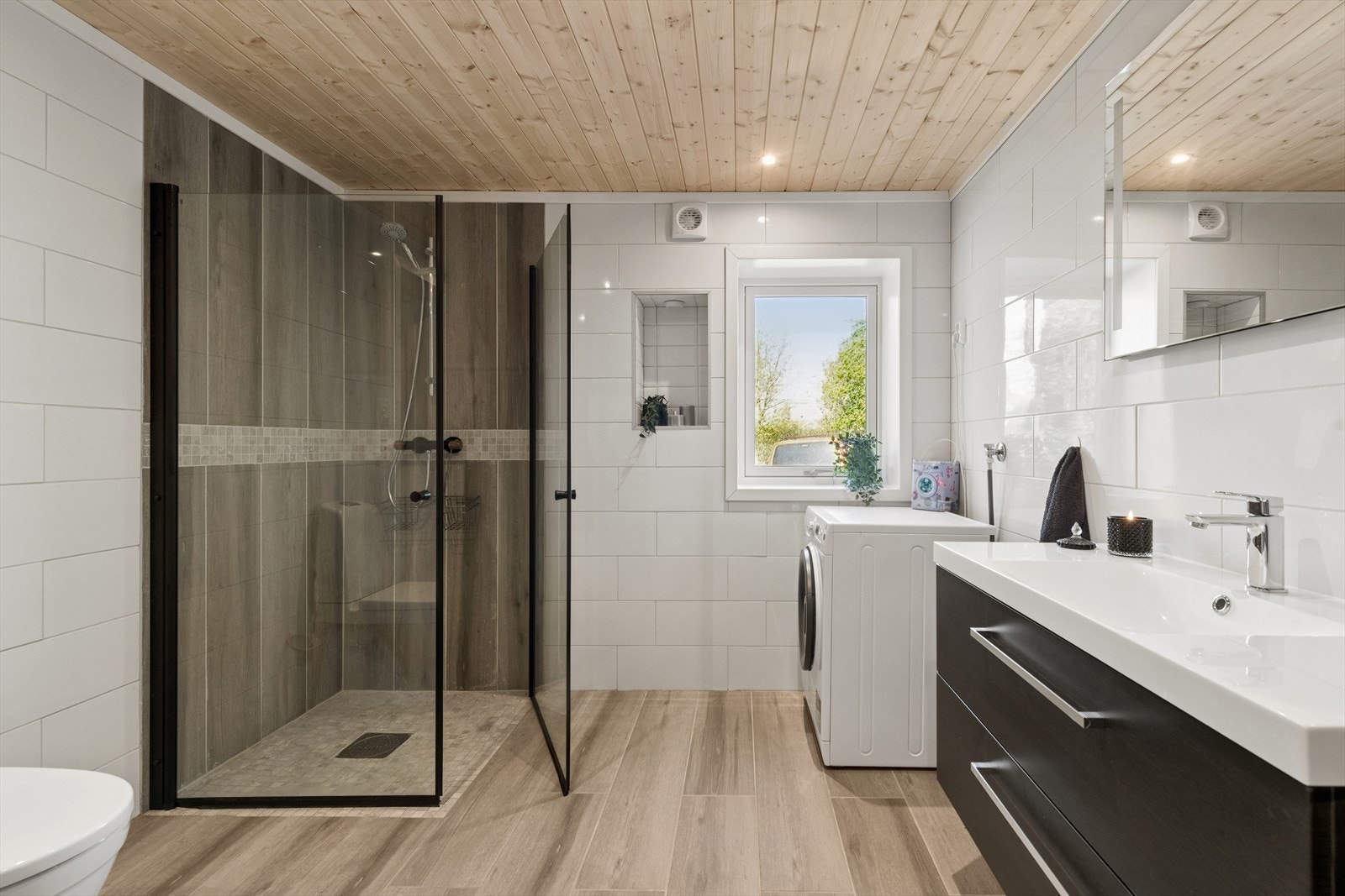 Badet har dusjhjørne og opplegg for vaskemaskin. Galleribilde