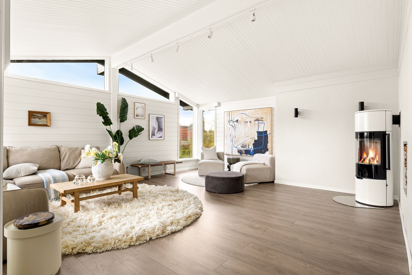 Lys og innbydende stue malt i lyse farger og lekkert laminat på gulvet. Galleribilde
