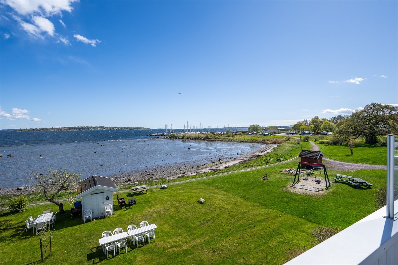 Utsyn over felles hage med Kyststien på nedsiden, og lekeplass på nabotomten. Galleribilde