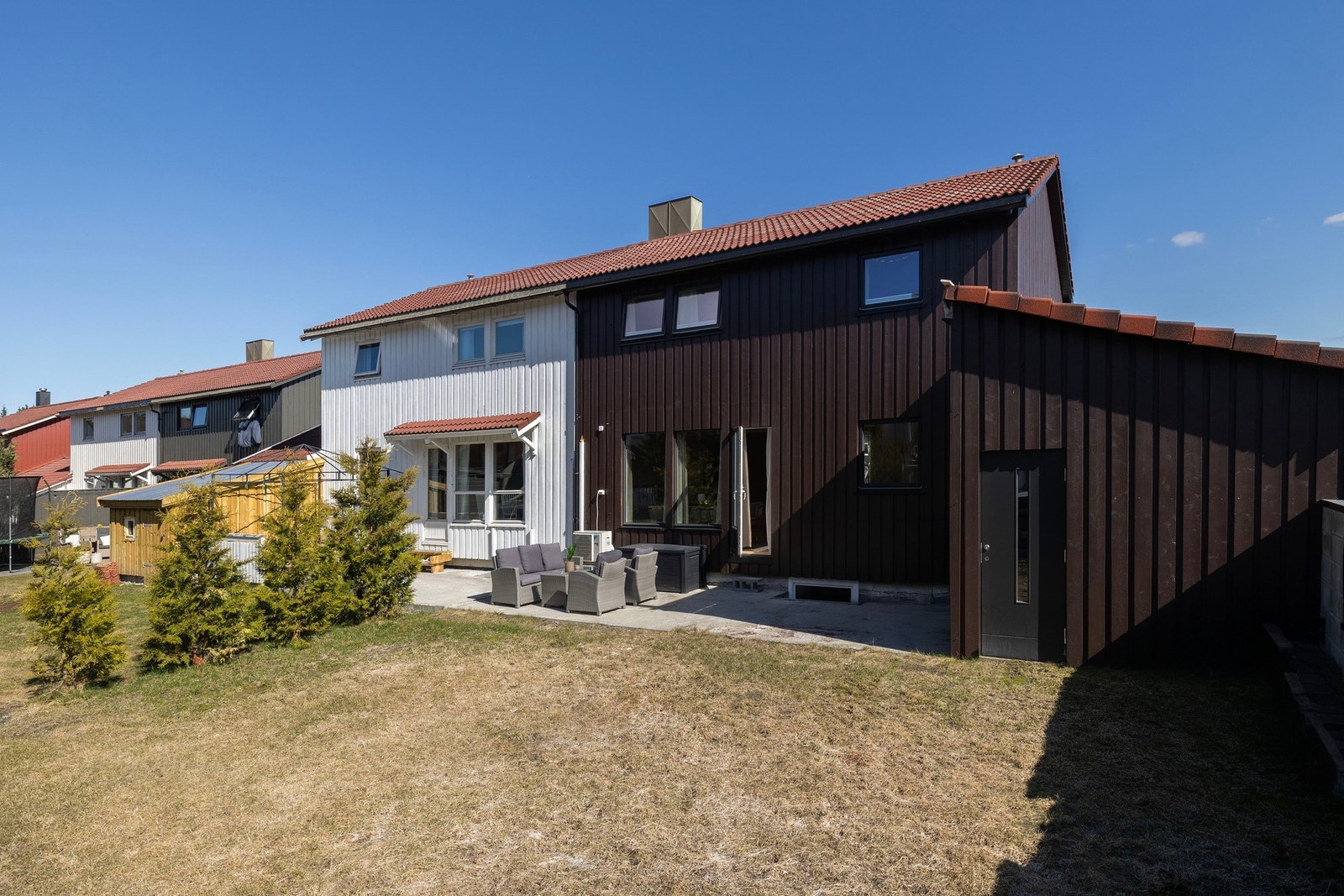 Hage, terrasse og innga til bod i bakkant av garasjen. Galleribilde