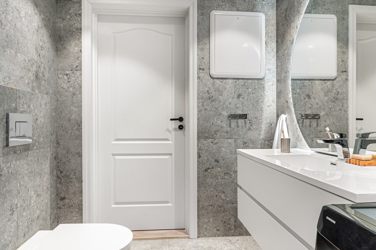 Badet er innredet med vegghengt toalett, dusjhjørne med dusjvegger og lekker nisje, og baderomsmøblement med speil og belysning. Galleribilde