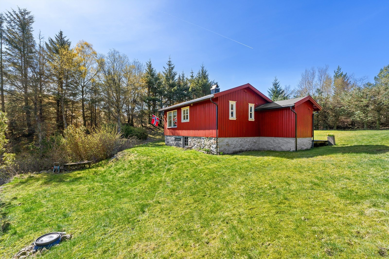 Eiendommen har en klassisk rød fasade og grunnmur i naturstein. Galleribilde