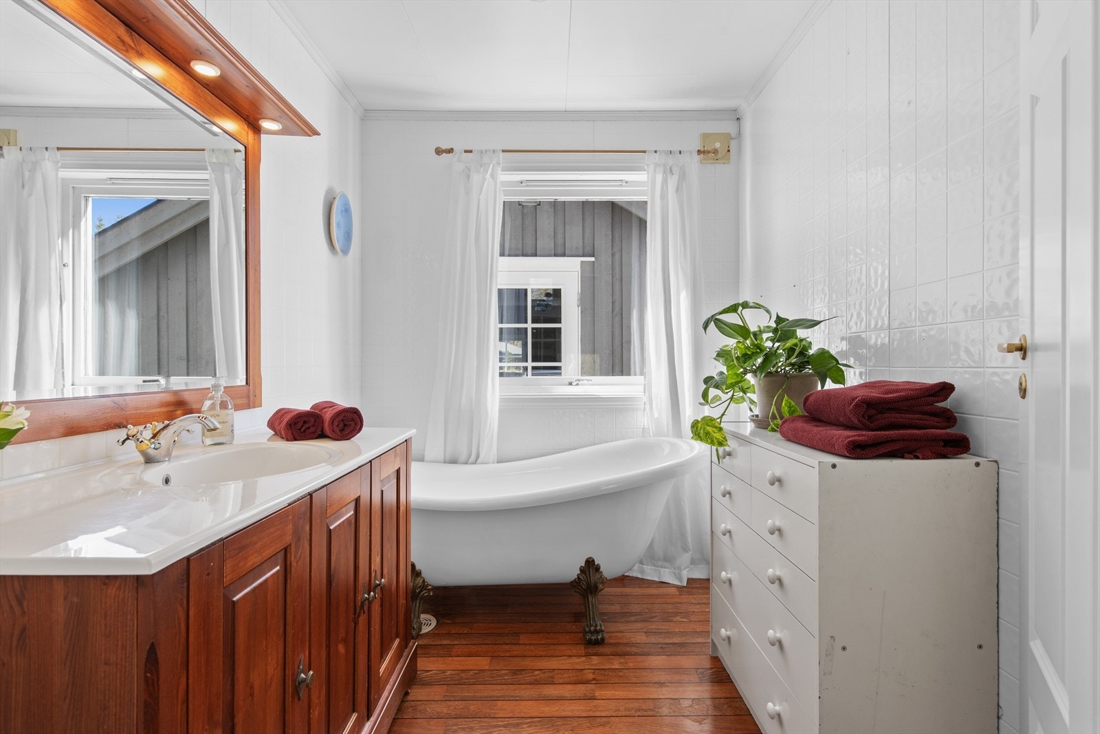 Badet fremstår funksjonelt utformet med servantinnredning, oppbevaringsmuligheter og badekar. Galleribilde