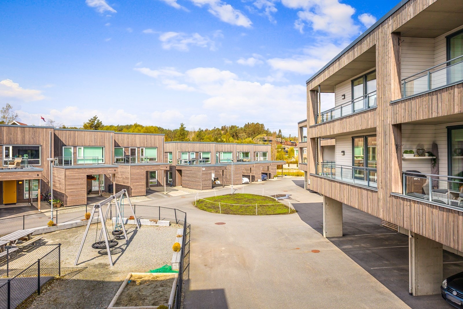 Pent opparbeidet med beplantninger, plenpartier, interne, asfalterte veier. Galleribilde