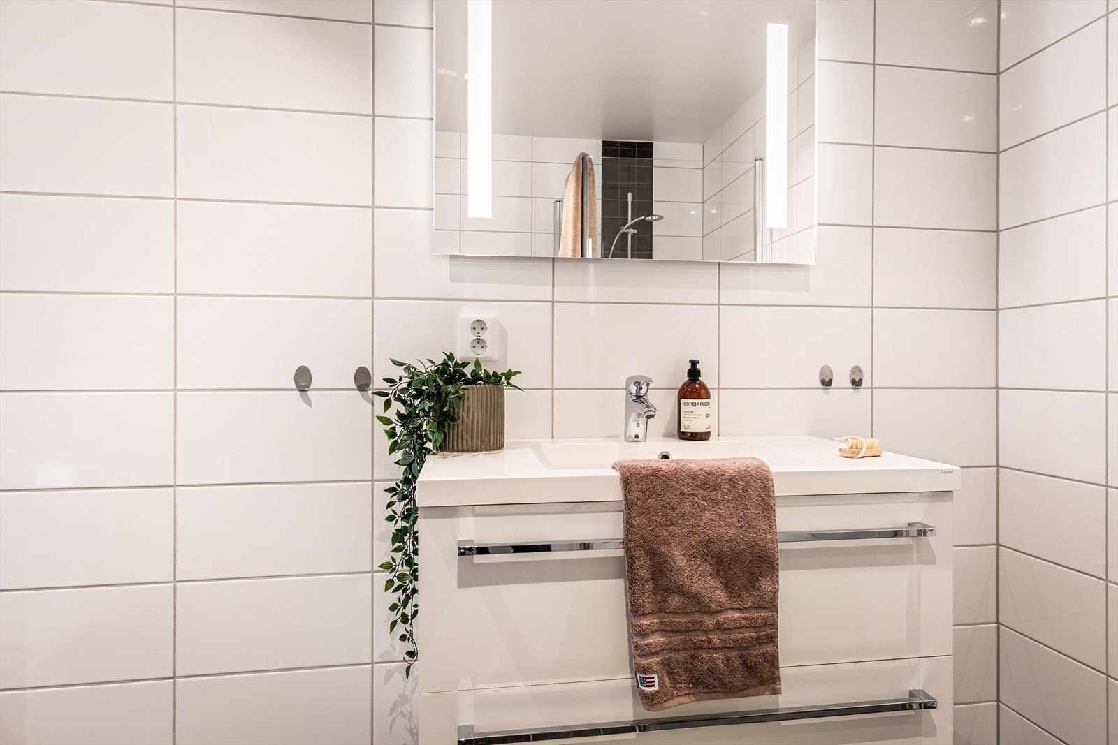 Det er montert håndkleoppheng på hver side av vasken. Galleribilde