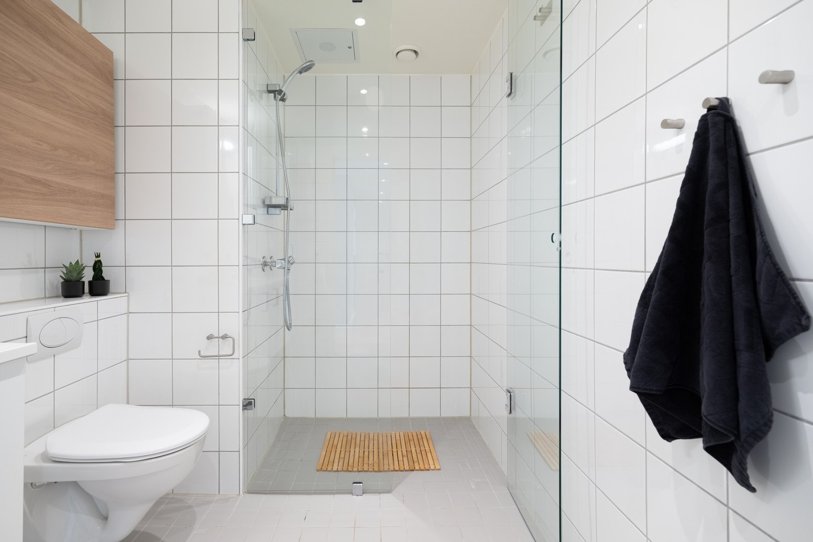 Badet har vegghengt toalett og romslig dusjnisje med glassvegg- og dør. Galleribilde