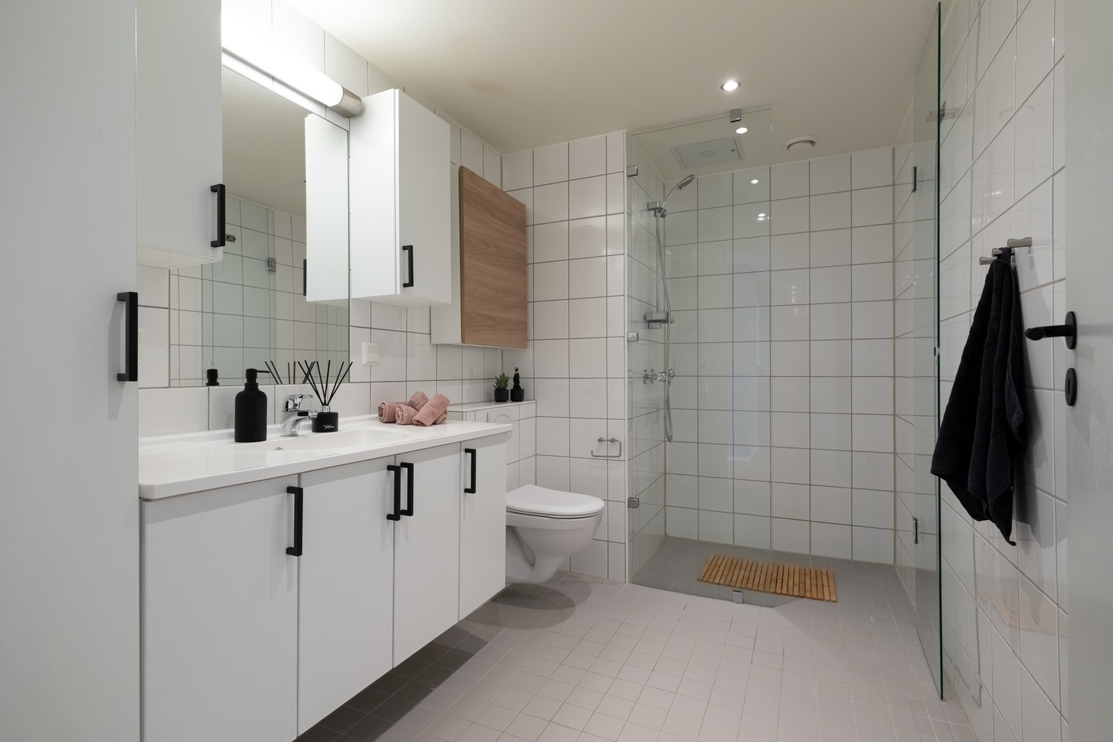 Boligens bad er lys, flislagt med varme i gulv og downlights i himling. Galleribilde