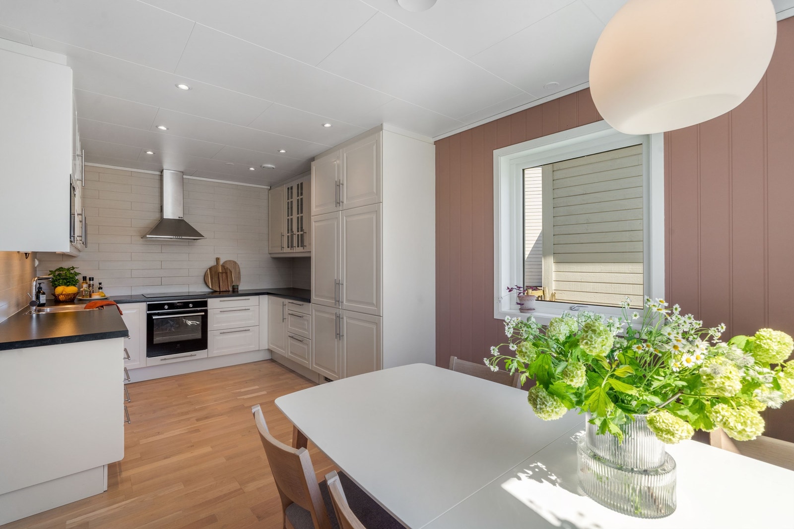 Kjøkkenet har en virkelig innholdsrik innredning og dermed rikelig med både skap og benkeplass. Her er det også plass til spisebord. Dette gjør rommet til et naturlig samlingspunkt for hele familien. Galleribilde