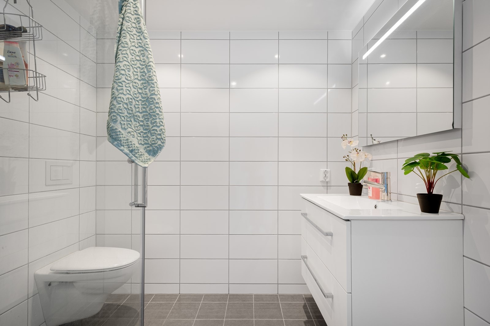 Badet i denne etasjen er også helfliset og er innredet med baderomsinnredning med servant, vegghengt toalett og dusj. Galleribilde