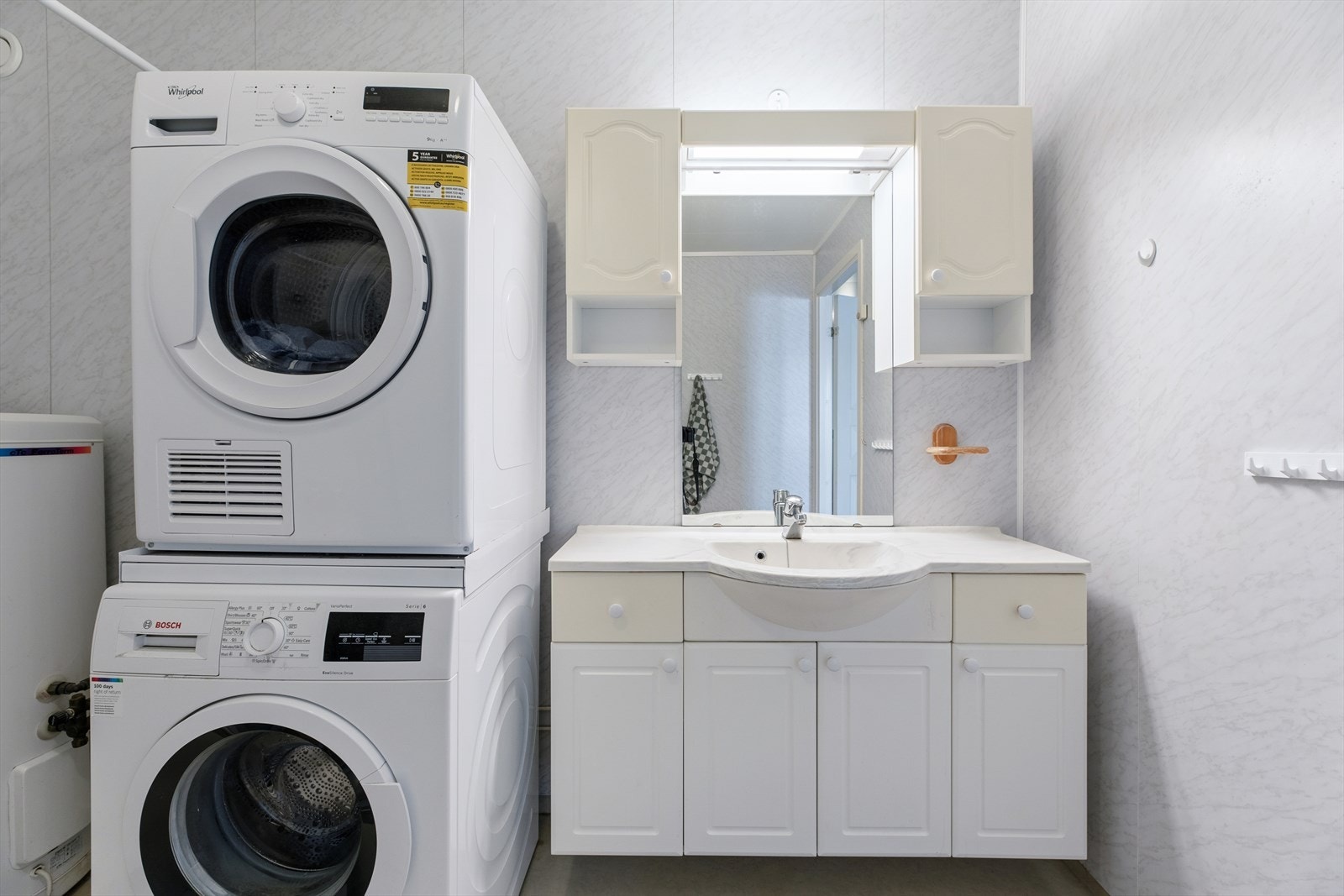 Badet er kombinert vaskerom med praktisk opplegg for vaskemaskin og tørketrommel. Galleribilde