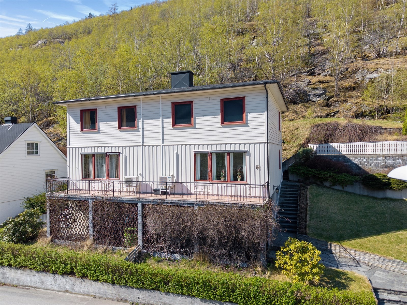 Uteområdet består av ein skrånande tomt med terrasse og hage. Galleribilde