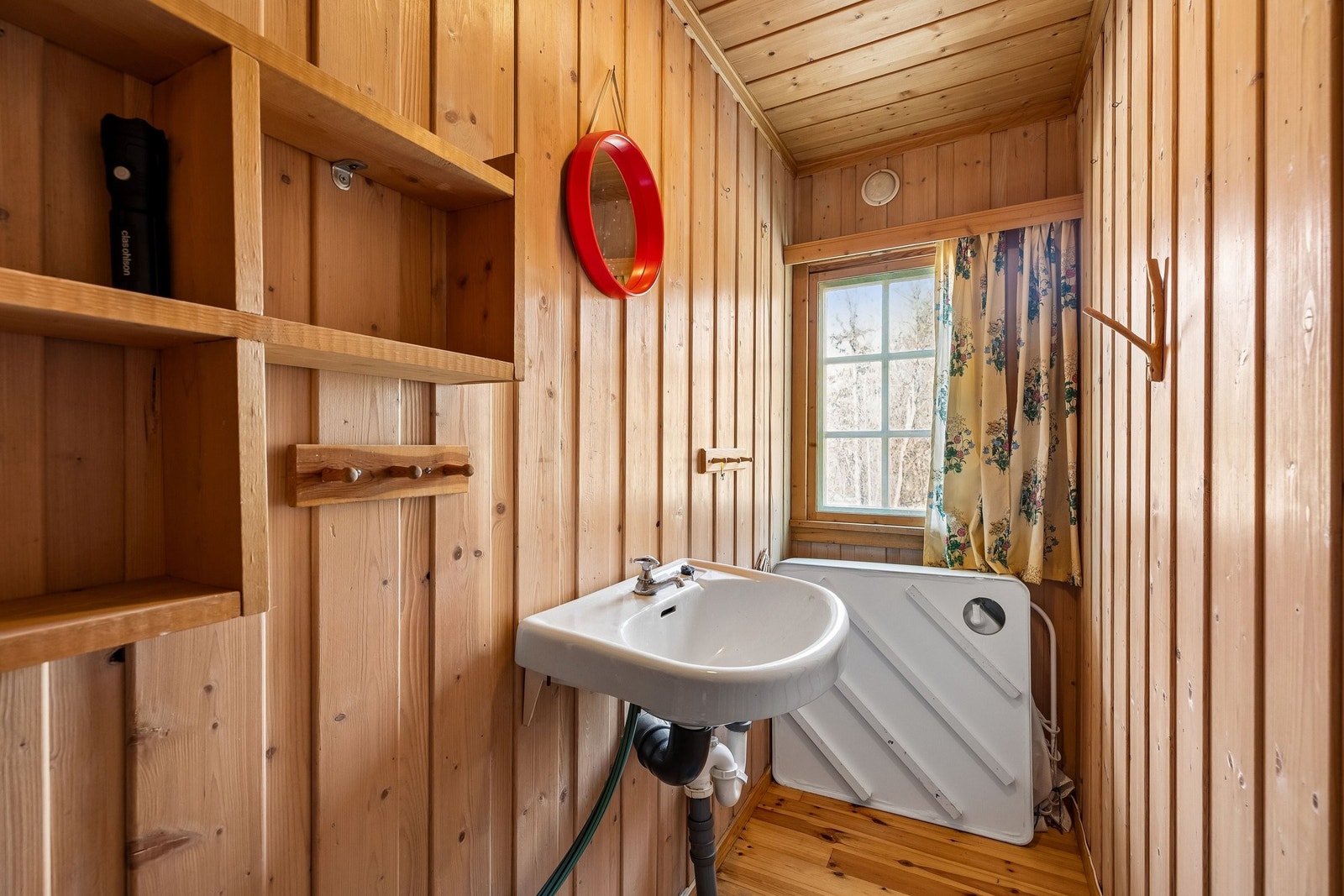 Badet har en vask og utstyr for dusj Galleribilde
