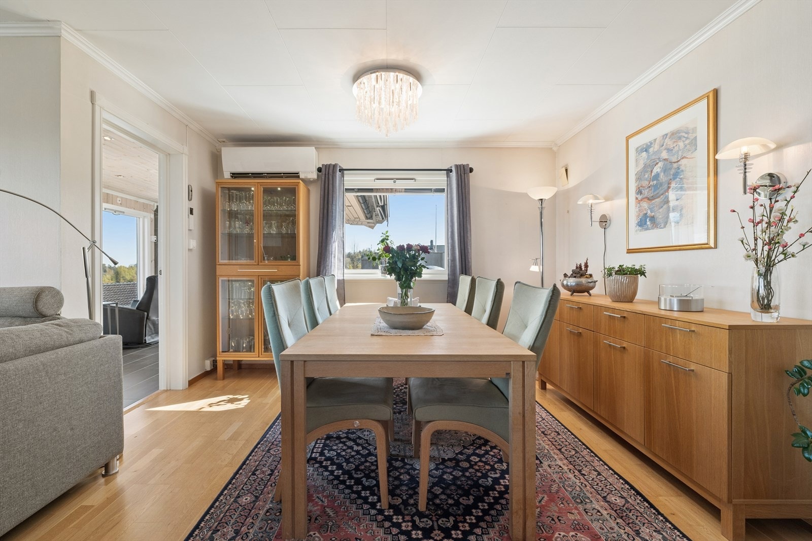 Stuen har god plass til stort spisebord, så her kan du invitere venner og familie til sosiale sammenkomster. En praktisk varmepumpe sørger for både kjøling og oppvarming av boligen etter behov. Galleribilde