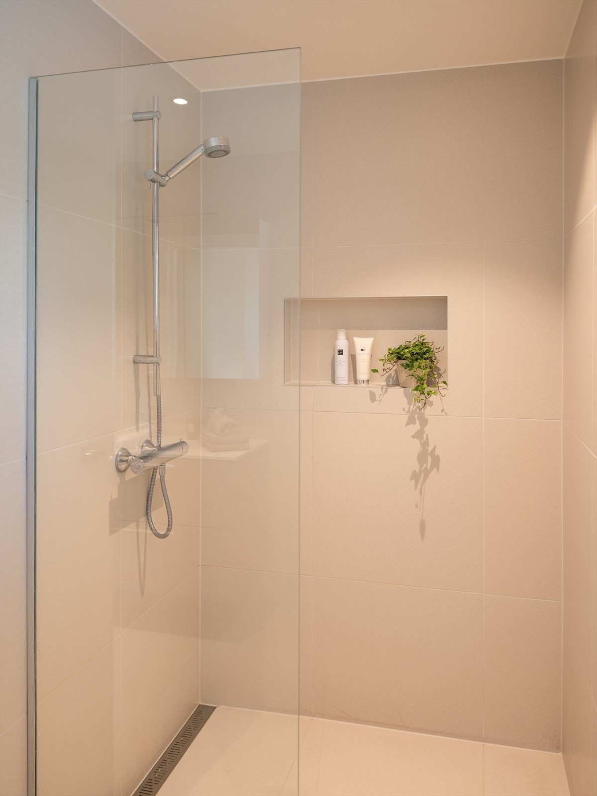 Videre byr badet på stor og romslig dusj, vegghengt toalett, innfelt dusjnisje og servant. Galleribilde