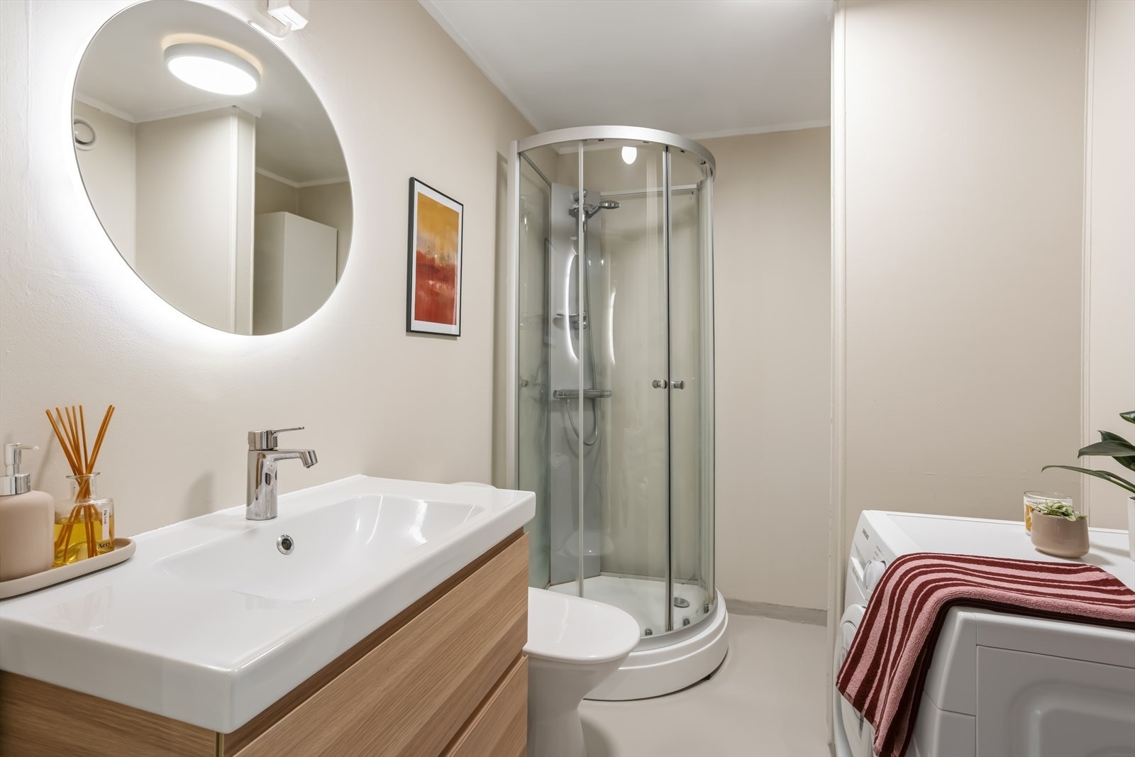 Badet fremstår moderne og tiltalende med stilren mikrosement på gulv, behagelige varmekabler og lyse, malte flater som gir et rolig og elegant uttrykk. Galleribilde