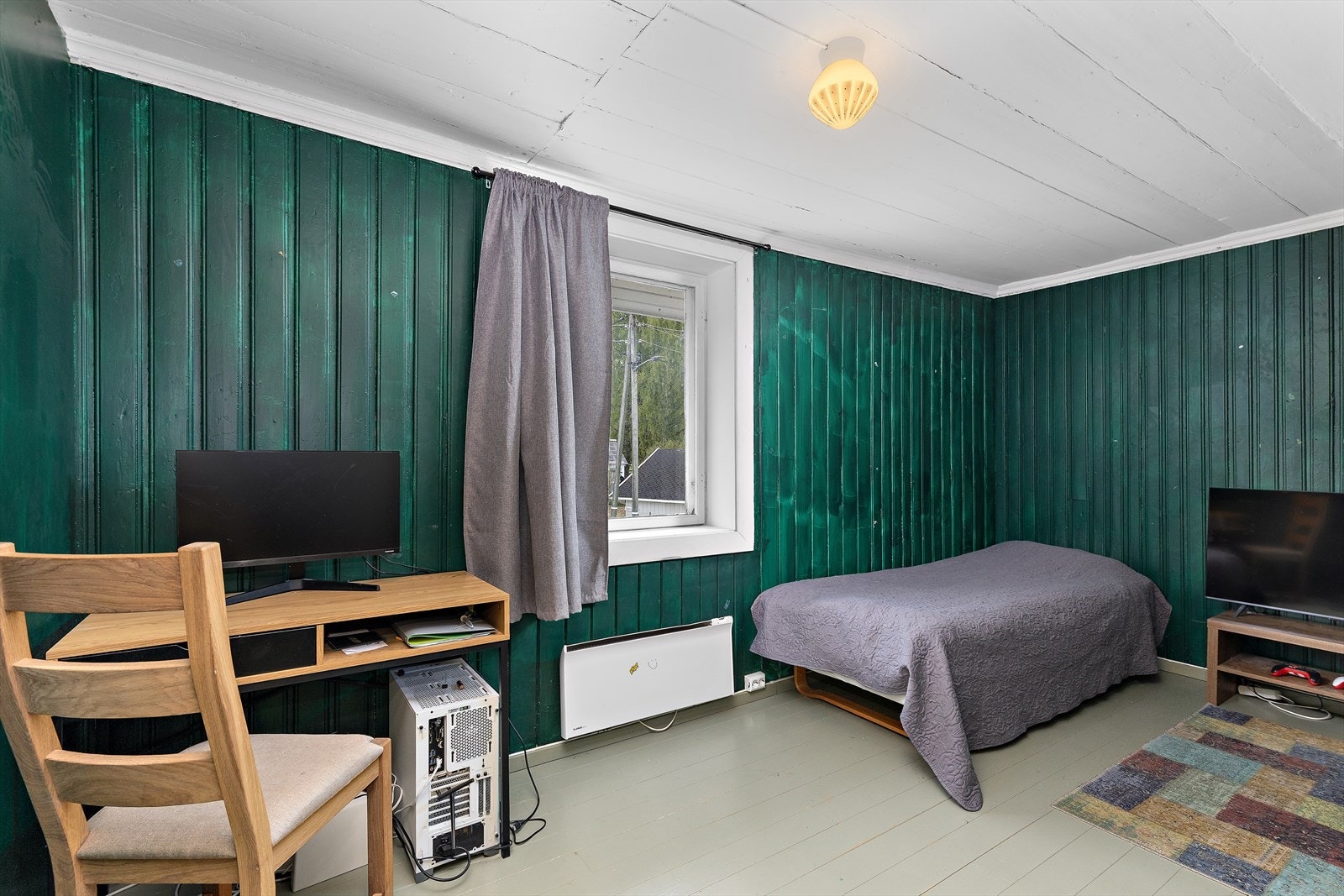 Dette soverommet har malt tregulv og panel på veggene. Galleribilde