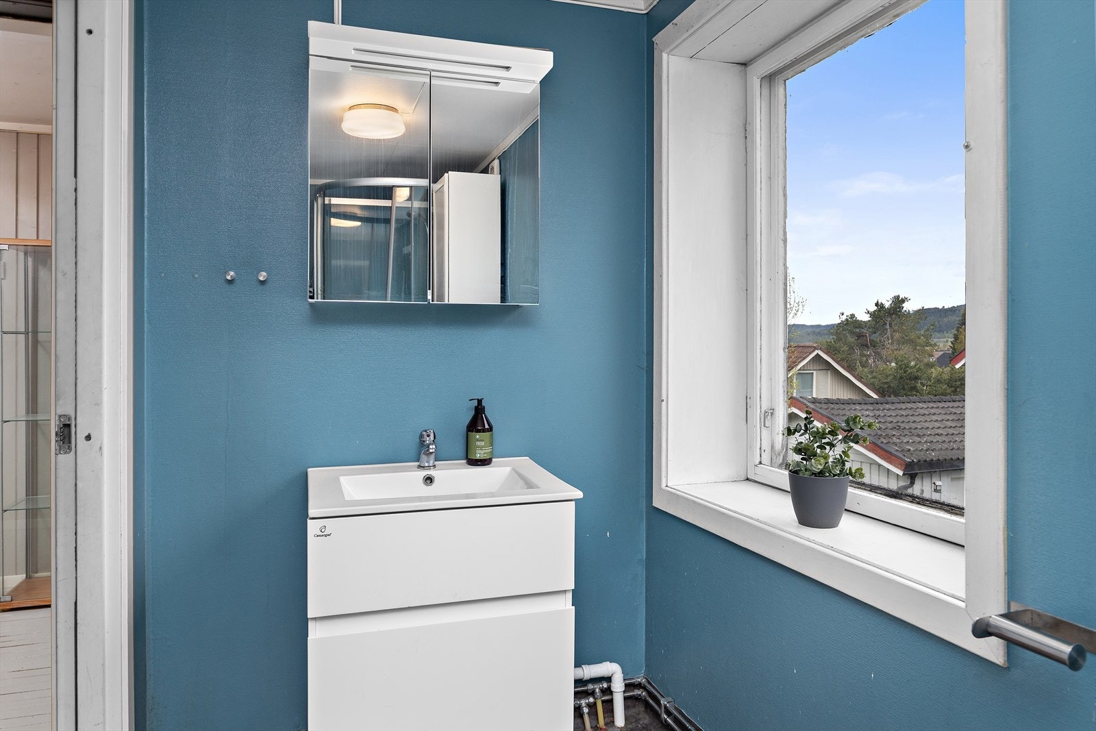 Badet er innredet med servant med underskap og et praktisk speilskap for oppbevaring. Galleribilde
