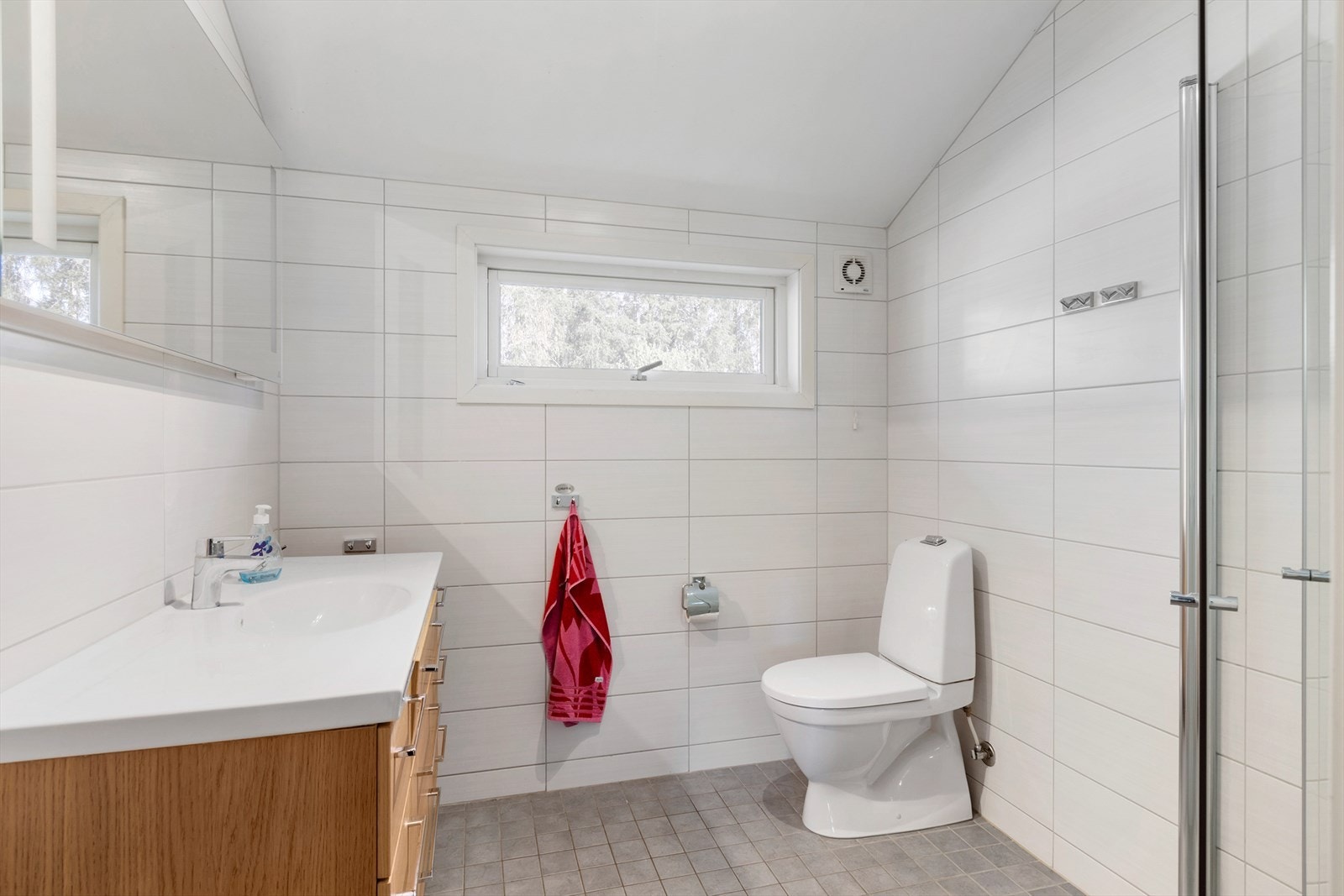 Bad i hovedetasje. Lyst og pent med fliser på gulv og vegger. Varme i gulv. Badet var nytt i 2012 og inneholder dusjhjørne, toalett, servant med skuffer og speil med belysning. Galleribilde