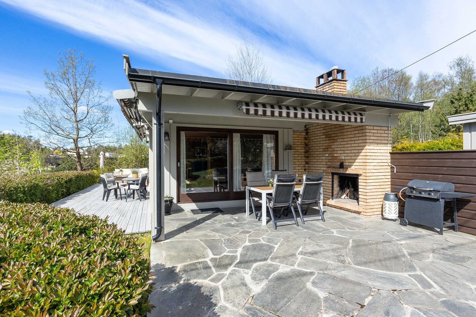 Den store terrassen har en flott, overbygd uteplass med åpen peis i teglstein. Galleribilde