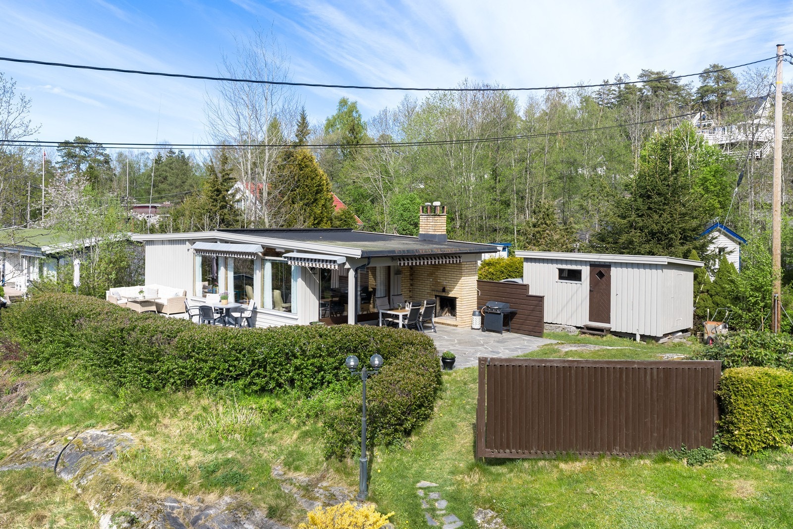 En oversikt over eiendommen som viser hytta, terrassen og boden. Galleribilde