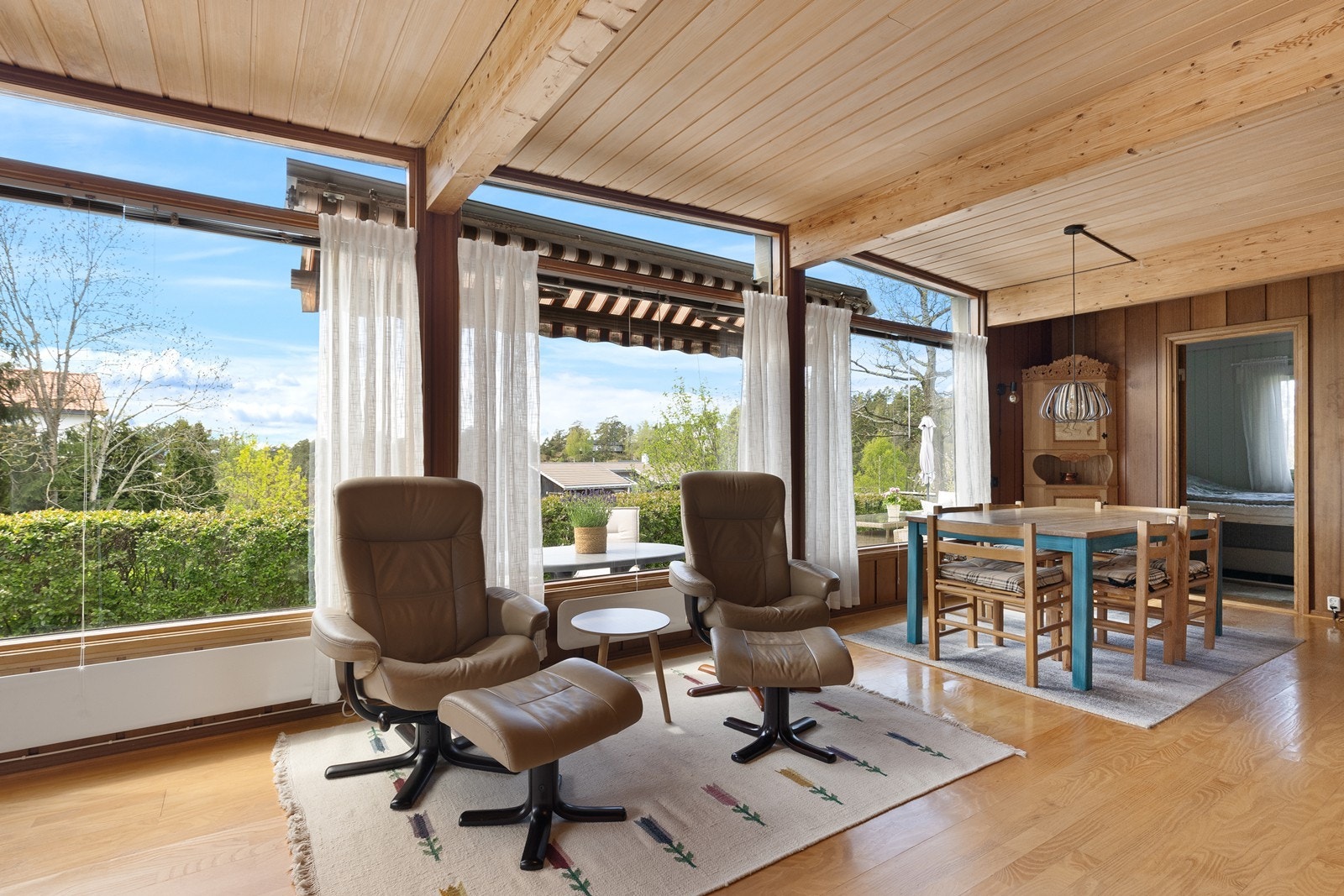 Store vindusflater i stuen rammer inn utsikten mot hagen. Galleribilde