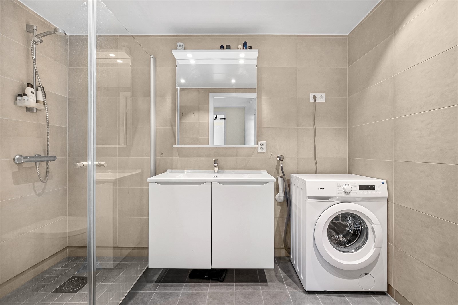Badet er lyst og moderne med flislagte vegger og gulv. Varmekabler i gulvet. Galleribilde