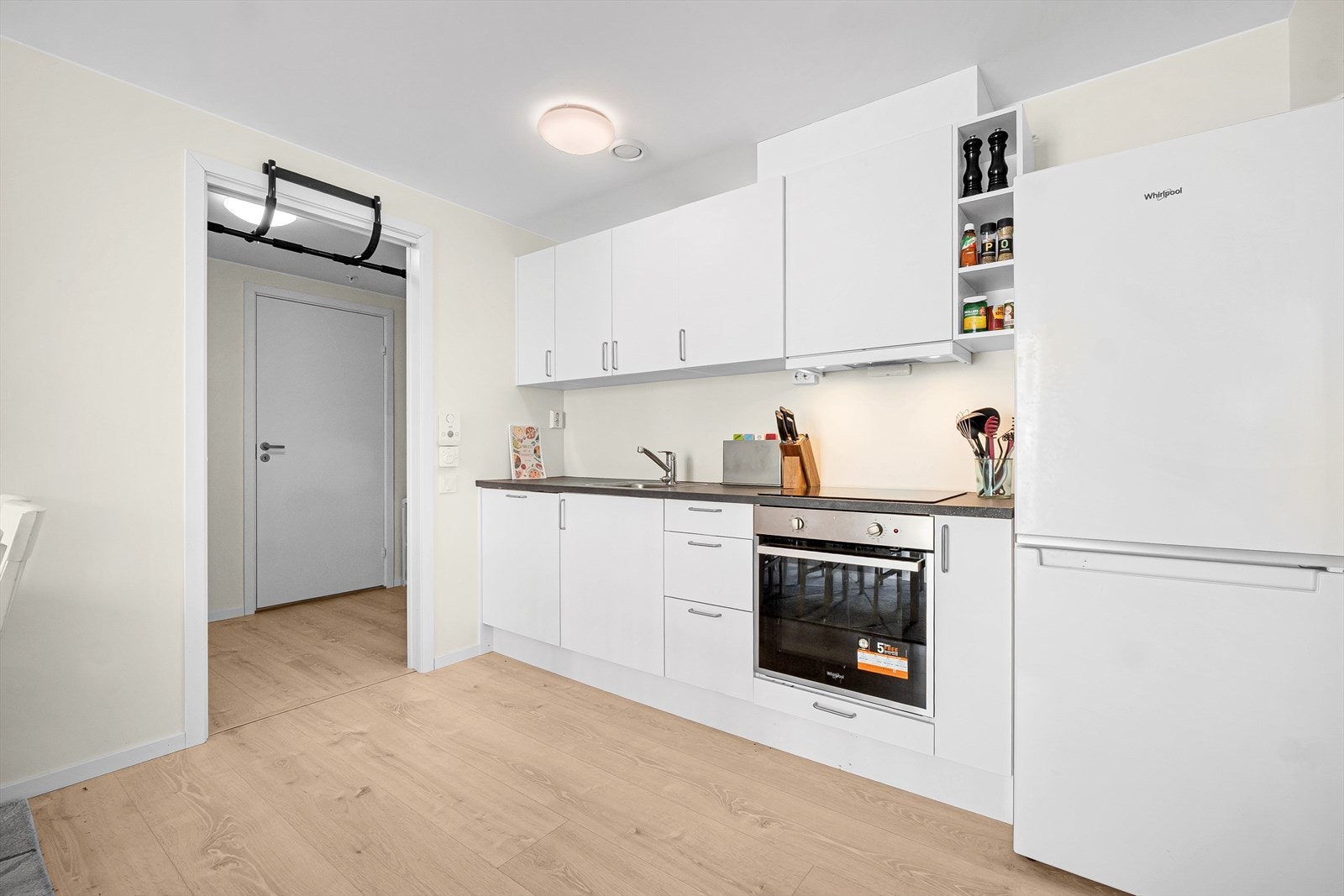Kjøkkenet står i åpen løsning mot stuen og er innredet med lyse, glatte fronter og benkeplate i laminat. Galleribilde