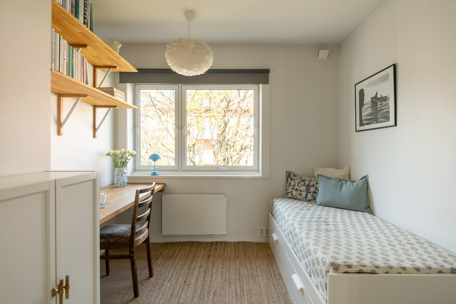 Soverom 2 fremstår som et lyst og innbydende med plass til seng med tilhørende nattbord, garderobeløsning og eventuelt skrivepult, fint plassert foran det store vinduet med hyggelig utsyn. Galleribilde