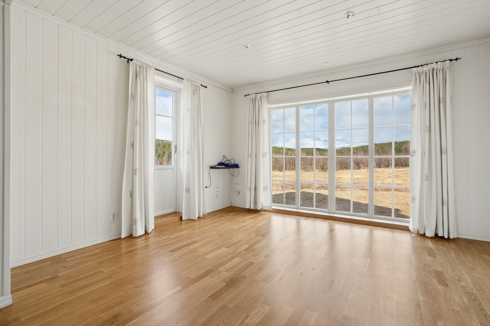 Store vindusflater slipper inn rikelig med dagslys og rammer inn utsikten mot naturen. Galleribilde